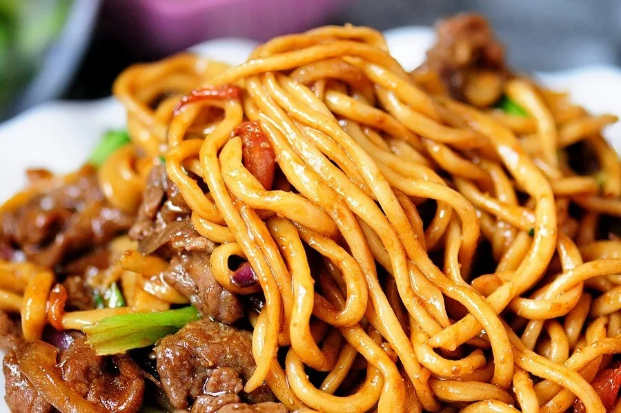 Stir-fried noodles with beef in a wok